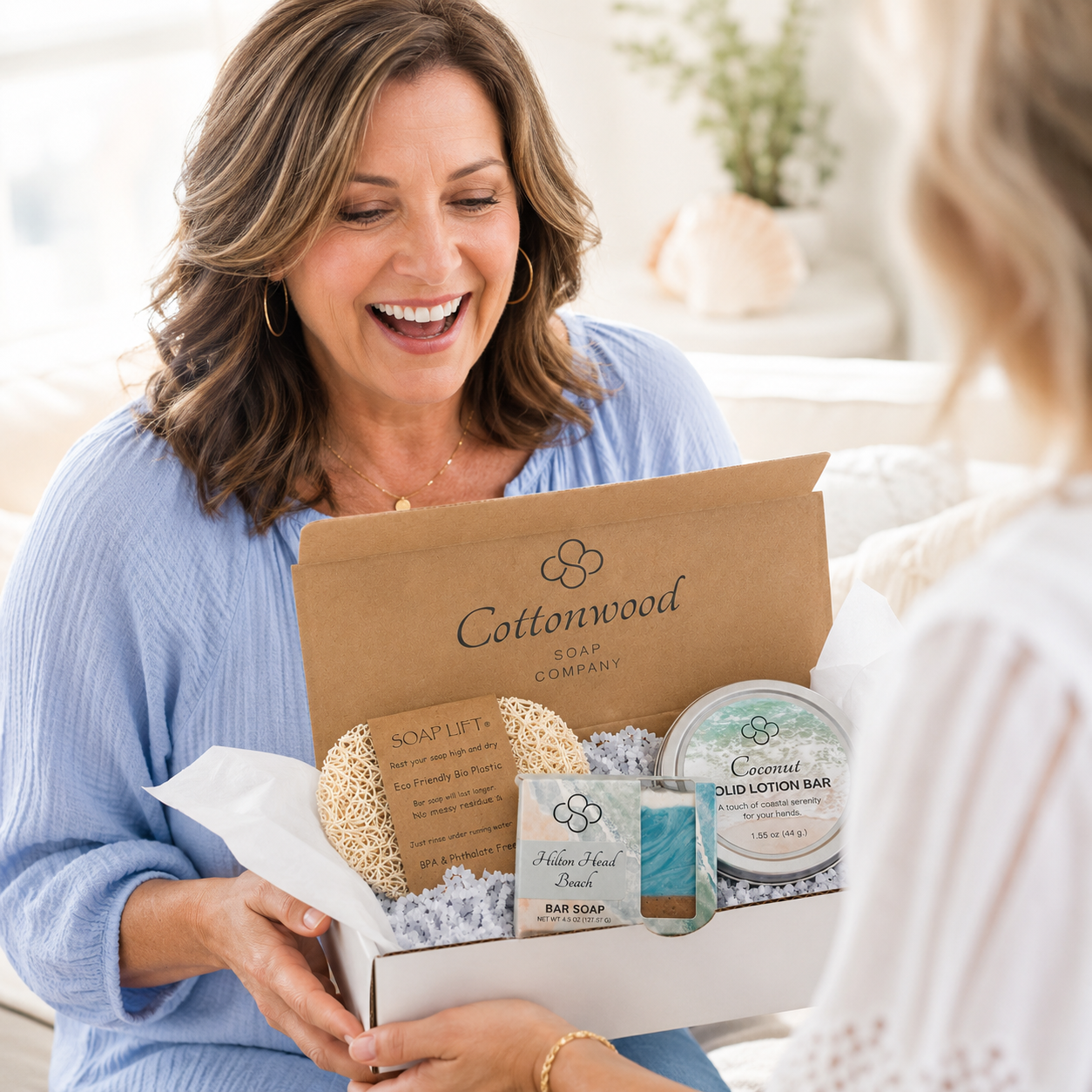 Woman opening a Cottonwood Soap Company coastal inspired bath and body gift box
